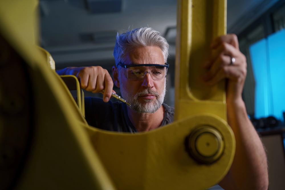 A site manager inspects a piece of equipment as part of routine plant maintenance